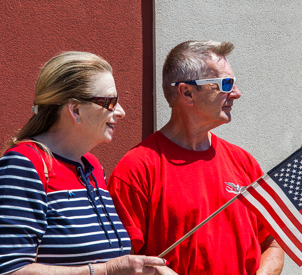 woman holding flag, and man looking to their left
