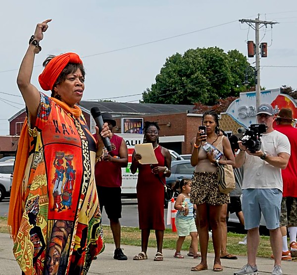 Woman with raised arm, speaking