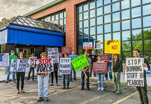people holding signs in front of building