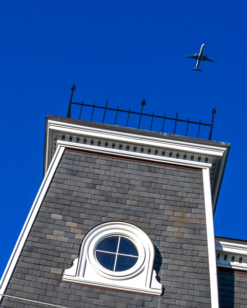 Airplane on path to land at Logan airport passes over Peabody city hall.