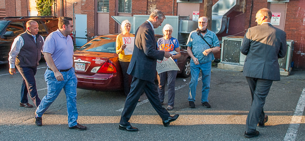 Governor Charlie Baker strides past demonstrators